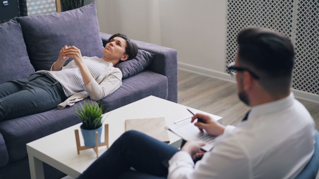 a man sitting on a couch next to a woman